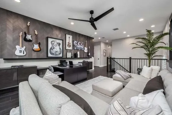 a living room with furniture and a ceiling fan