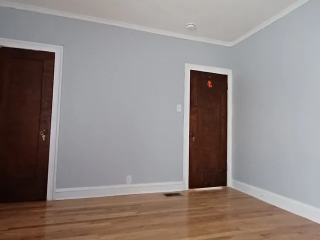 a view of an empty room with wooden floor