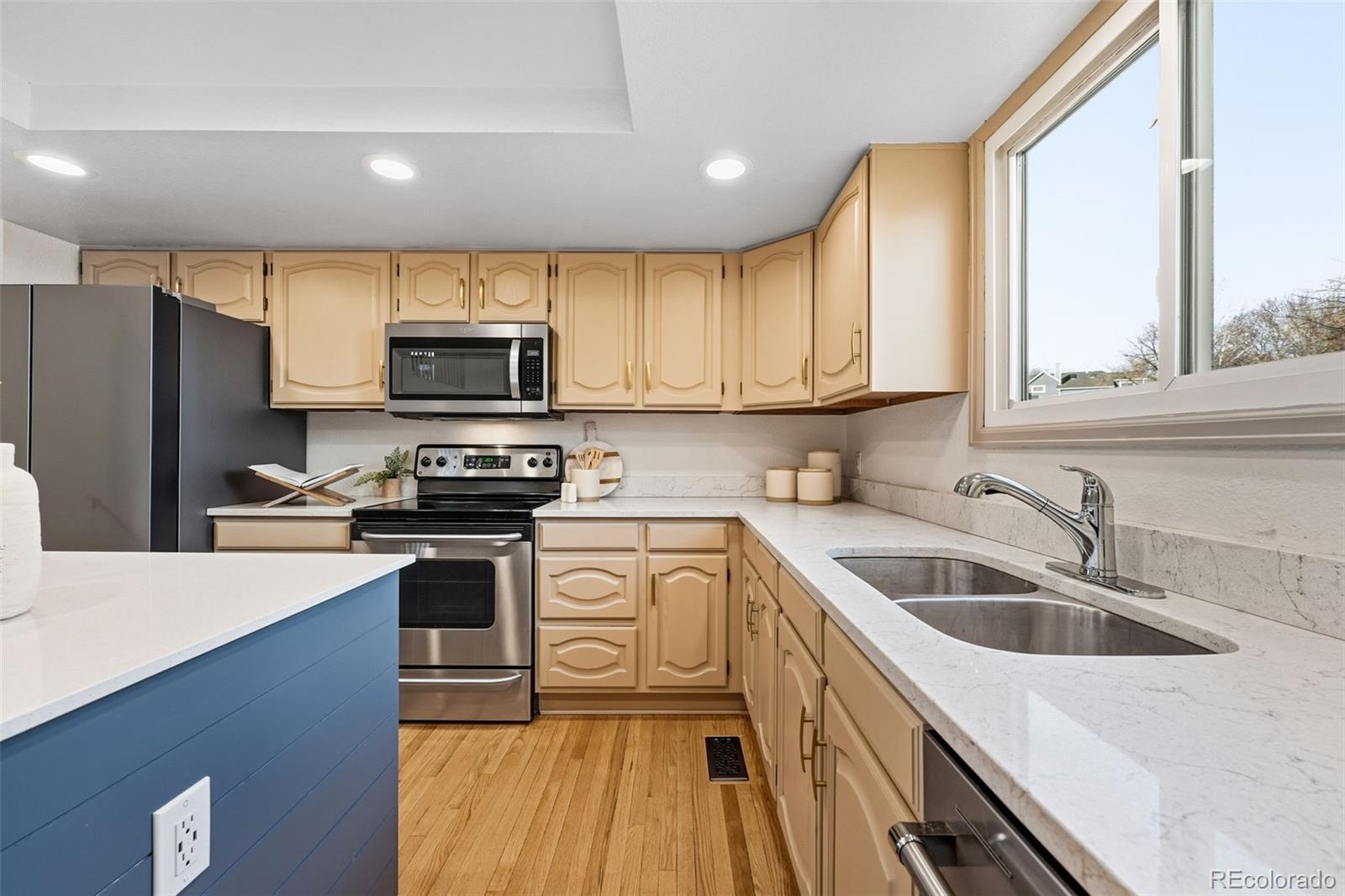 9426 Princeton Circle Highlands Ranch, CO 80130 - Photo 13 of 50 a kitchen with a sink a microwave a refrigerator and cabinets