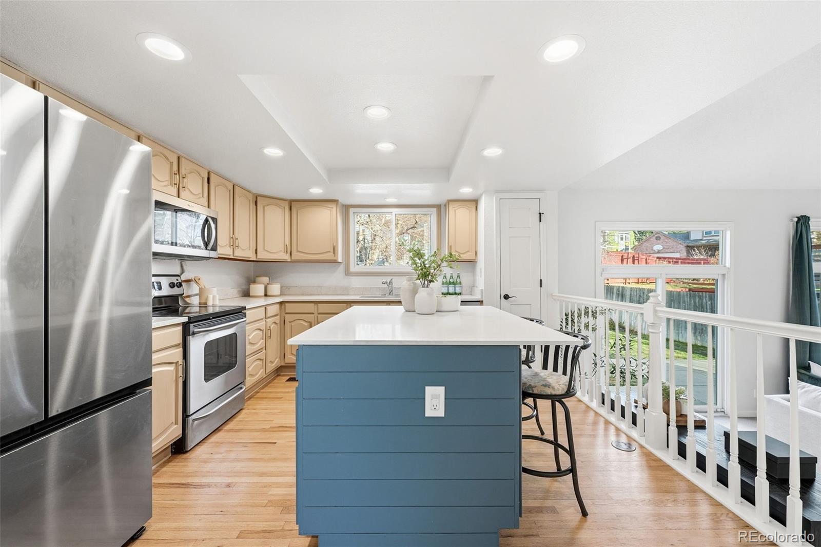 9426 Princeton Circle Highlands Ranch, CO 80130 - Photo 9 of 50 a kitchen with stainless steel appliances granite countertop a kitchen island wooden floors and white cabinets
