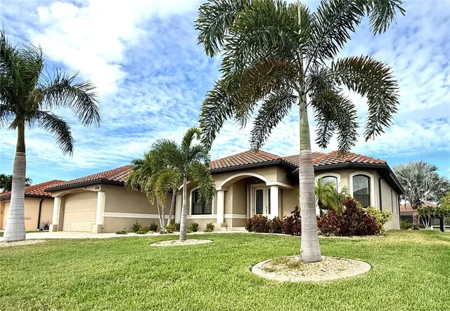 a front view of a house with garden and trees