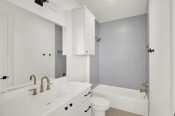 a bathroom with a toilet a sink a mirror and vanity