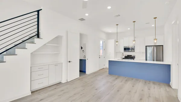 a large kitchen with cabinets wooden floor and stainless steel appliances