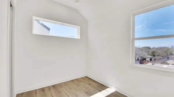 a view of hallway with wooden floor and a window