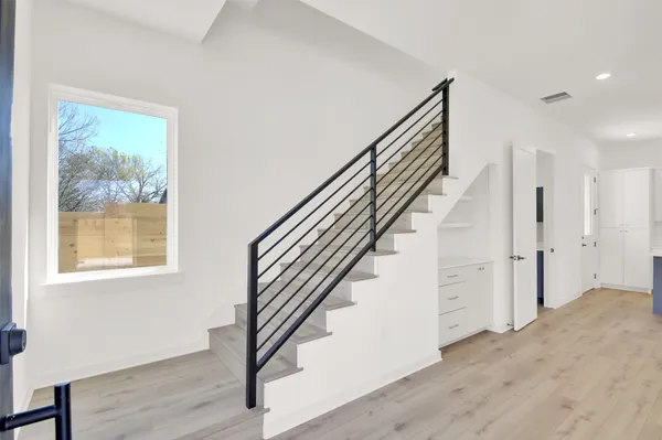 a view of a hallway with wooden floor and entryway