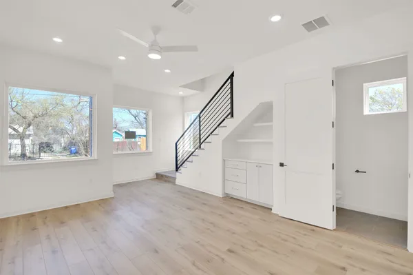 a large kitchen with stainless steel appliances a large counter top and a wooden floor