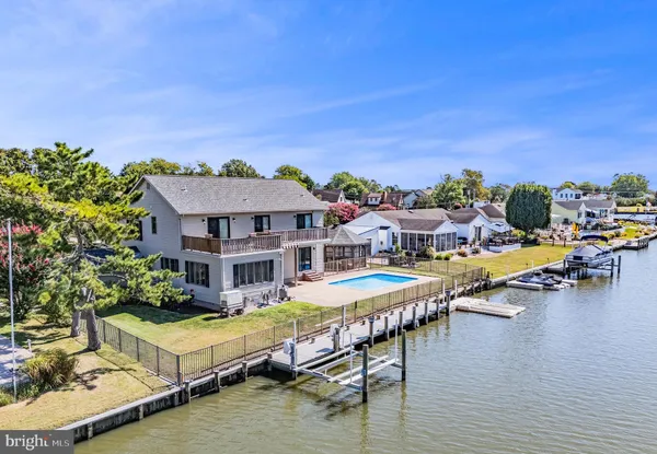 an aerial view of a house with swimming pool and furniture