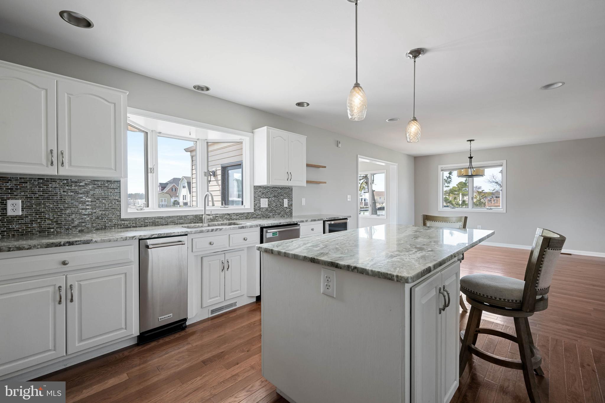 11 Arnell Road Rehoboth Beach, DE 19971 - Photo 6 of 46 a kitchen with granite countertop white cabinets and chairs
