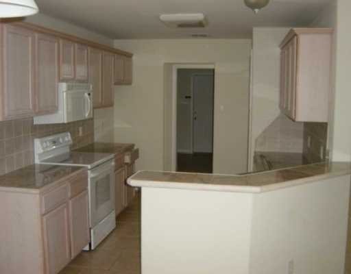 16002 Cuttysark Street Corpus Christi, TX 78418 - Photo 2 of 7 a kitchen with stainless steel appliances granite countertop a sink and a refrigerator