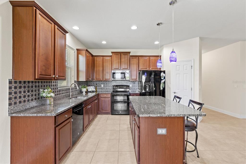 7923 111th Terrace East Parrish, FL 34219 - Photo 11 of 80 a kitchen with stainless steel appliances granite countertop a refrigerator sink and cabinets