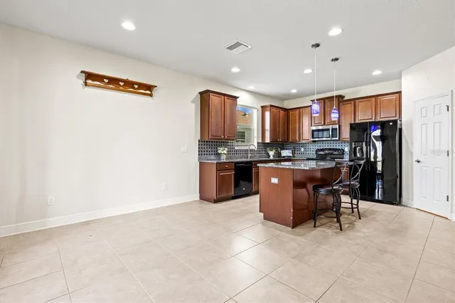 an empty room with wooden floor chandelier fan and windows