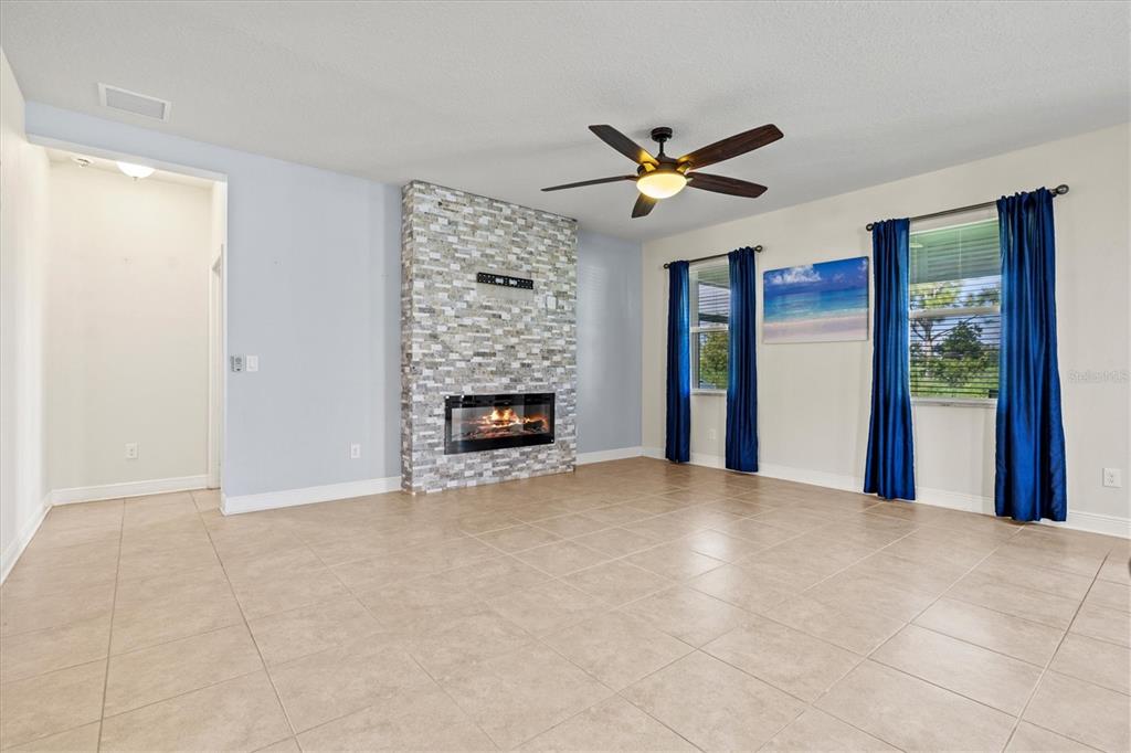 7923 111th Terrace East Parrish, FL 34219 - Photo 17 of 80 a view of an empty room with chandelier fan and a fireplace