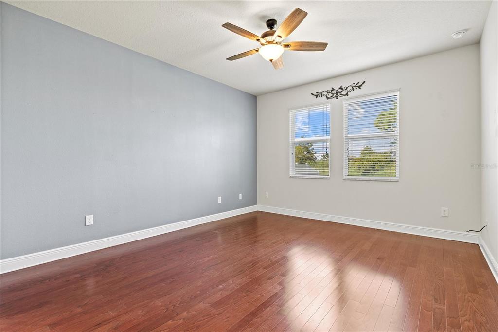7923 111th Terrace East Parrish, FL 34219 - Photo 21 of 80 an empty room with wooden floor chandelier fan and windows