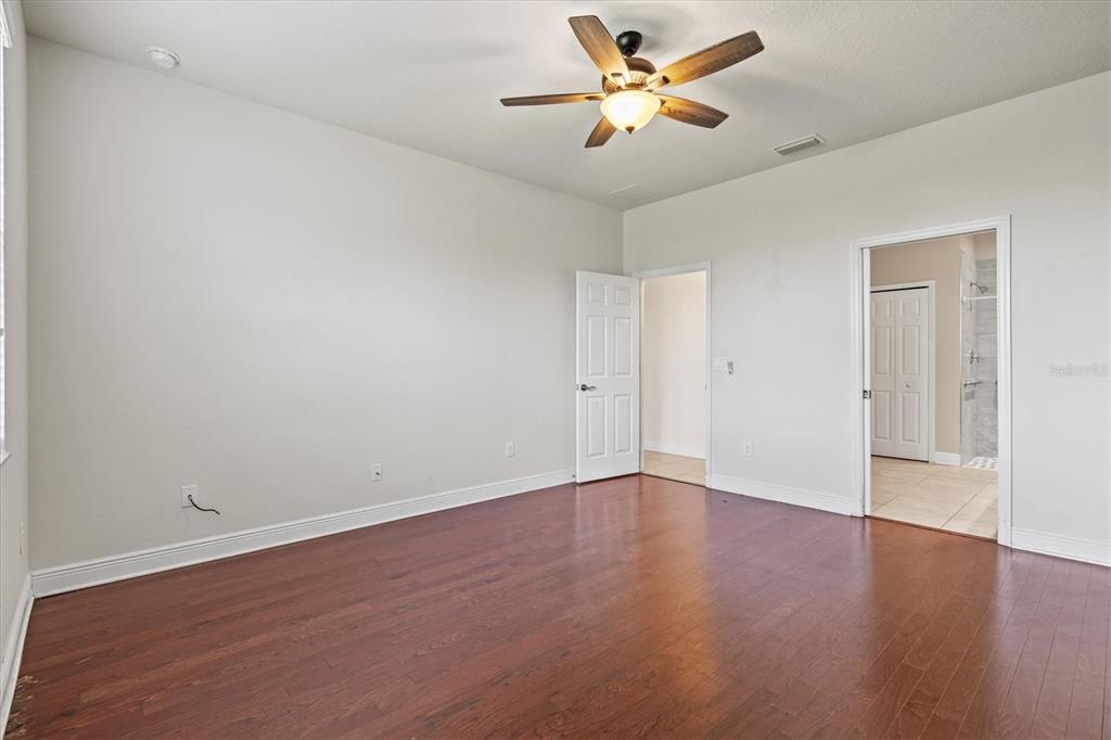 7923 111th Terrace East Parrish, FL 34219 - Photo 22 of 80 an empty room with wooden floor and a ceiling fan