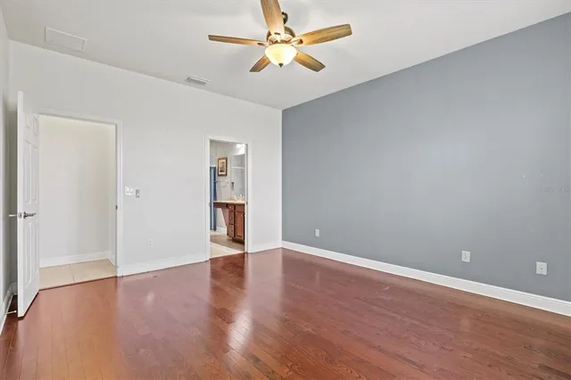 an empty room with a chandelier fan