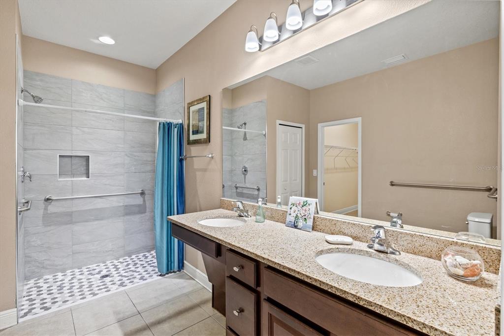7923 111th Terrace East Parrish, FL 34219 - Photo 24 of 80 a bathroom with a granite countertop double vanity sink a mirror and a shower
