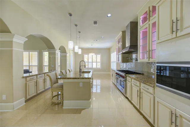 a large white kitchen with a large window appliances and cabinets