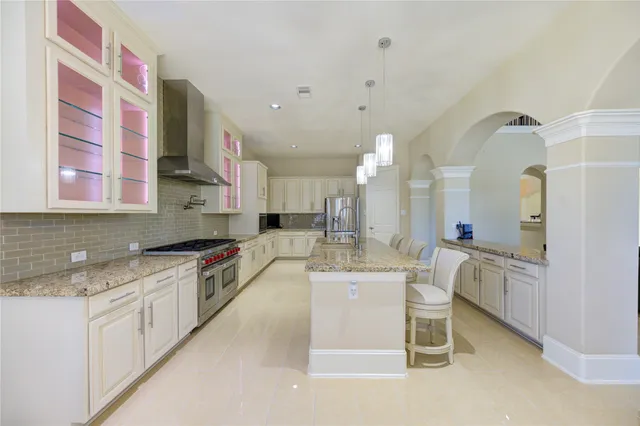 a large kitchen with stainless steel appliances kitchen island granite countertop a stove and cabinets