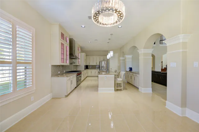 a view of a kitchen with kitchen island a stove a sink a refrigerator and a view of living room