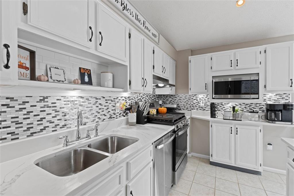 5079 Windriver Drive McKees Rocks, PA 15136 - Photo 15 of 50 a kitchen with white cabinets a sink and appliances