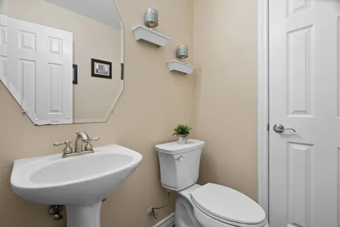 a bathroom with a sink toilet and a mirror