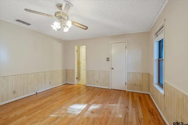 a view of a room with wooden floor and ceiling fan