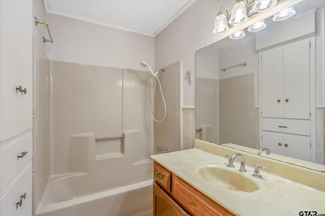 a bathroom with a sink double vanity granite tub shower and a mirror