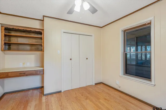 a view of an empty room with a window and wooden floor
