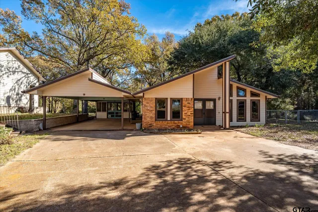 a front view of a house with a yard covered with snow