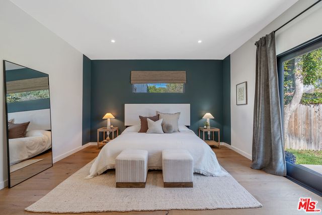 a bedroom with a bed and a large window