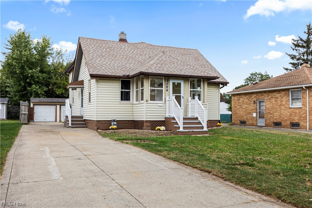 Bungalow featuring a front lawn and a garage
