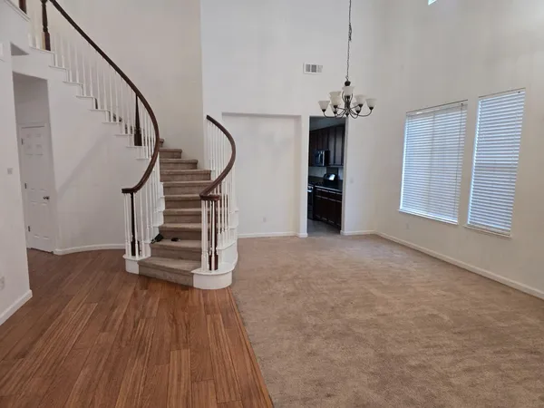 a view of empty room with stairs and wooden floor