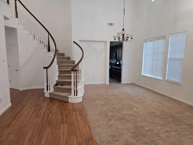 a view of empty room with stairs and wooden floor