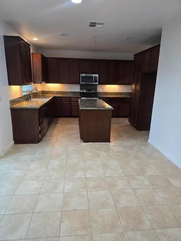 a kitchen with stainless steel appliances granite countertop a stove a sink and a refrigerator