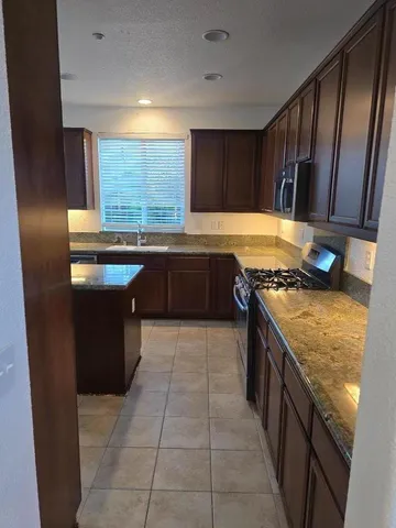 a kitchen with a stove sink and cabinets