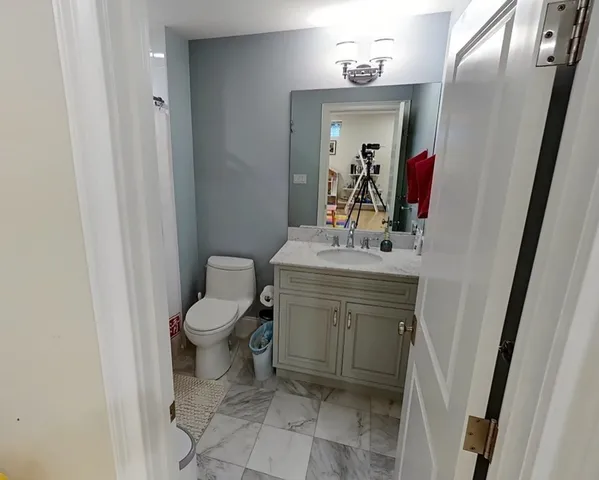 a bathroom with a toilet sink and mirror