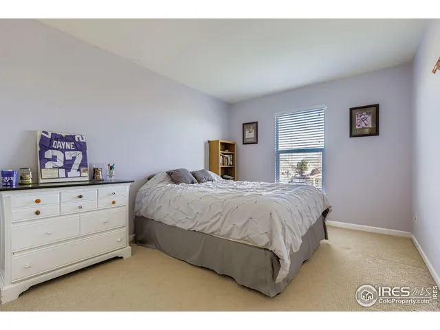 a spacious bedroom with a bed and painting on the wall