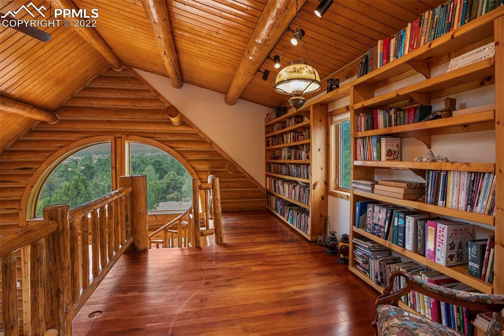 3311 County Road 103 Florence, CO 81226 - Photo 23 of 50 a hallway with wooden floor book shelves and a book shelf