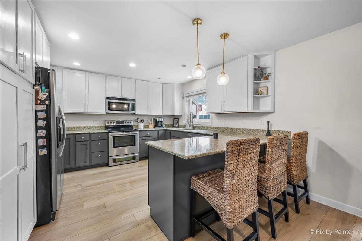 9520 Stacy Lane Union, IL 60180 - Photo 4 of 45 a kitchen with kitchen island granite countertop wooden cabinets and refrigerator
