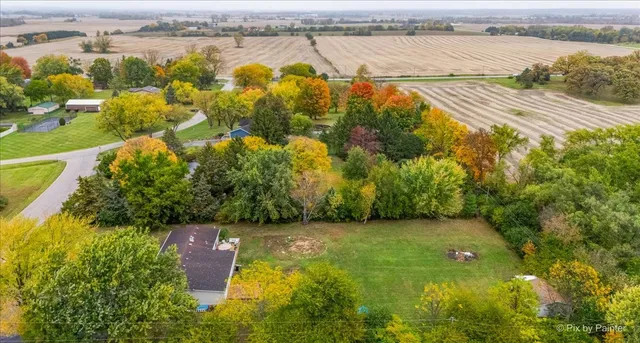 an aerial view of a house with backyard space and swimming pool