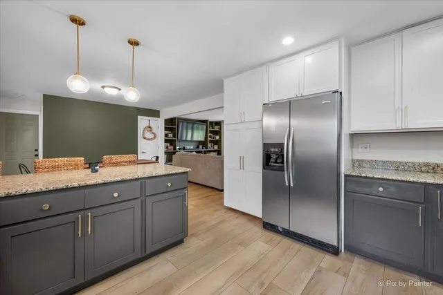 a bathroom with a granite countertop sink and a refrigerator