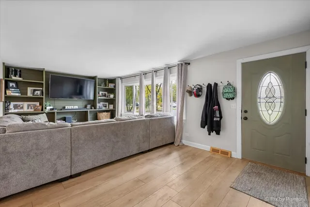 a living room with furniture a flat screen tv and a wall clock