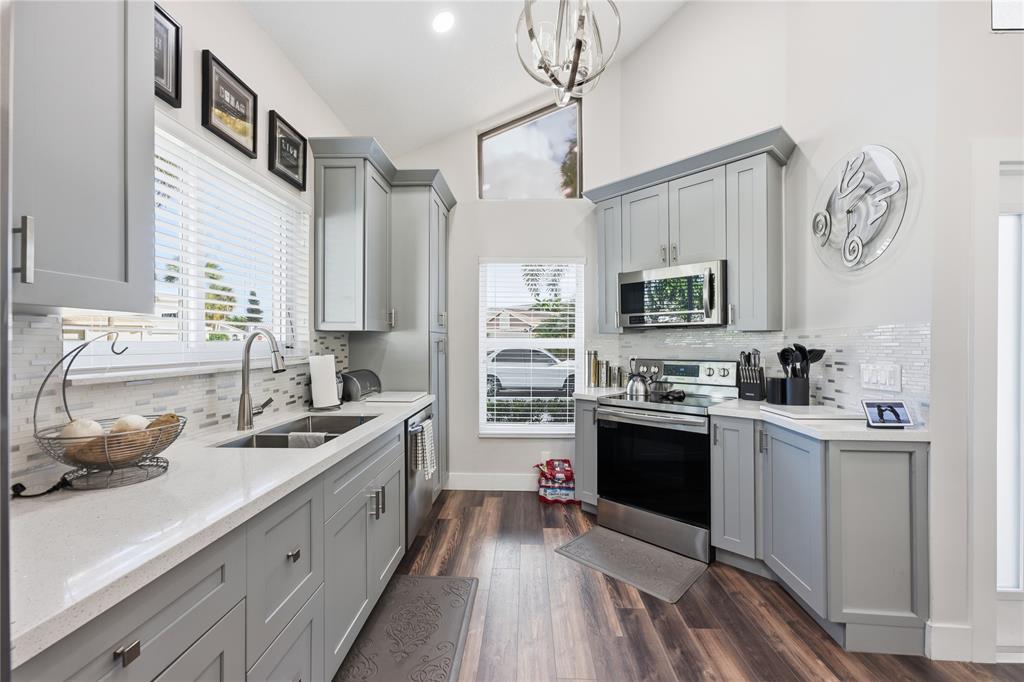 23367 Boca Trace Drive Boca Raton, FL 33433 - Photo 11 of 34 a kitchen with stainless steel appliances granite countertop a sink stove and refrigerator