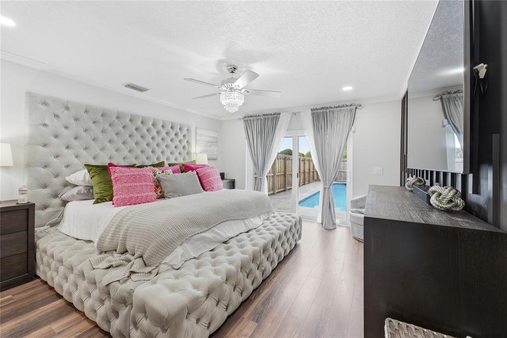 23367 Boca Trace Drive Boca Raton, FL 33433 - Photo 14 of 34 a bedroom with a large bed and a chandelier