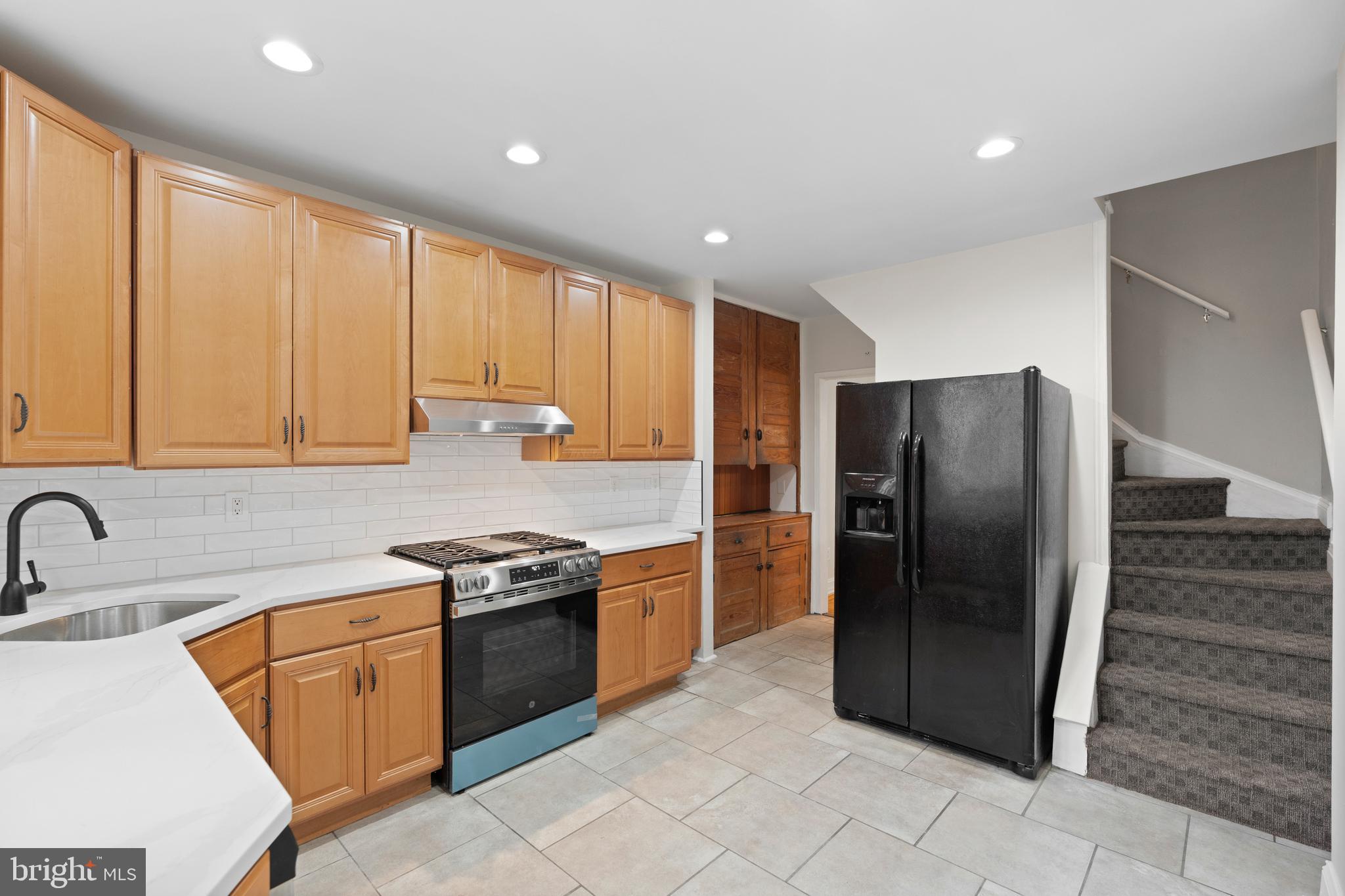 619 South 42nd Street Philadelphia, PA 19104 - Photo 11 of 30 a kitchen with stainless steel appliances granite countertop a refrigerator a sink a stove with wooden cabinets