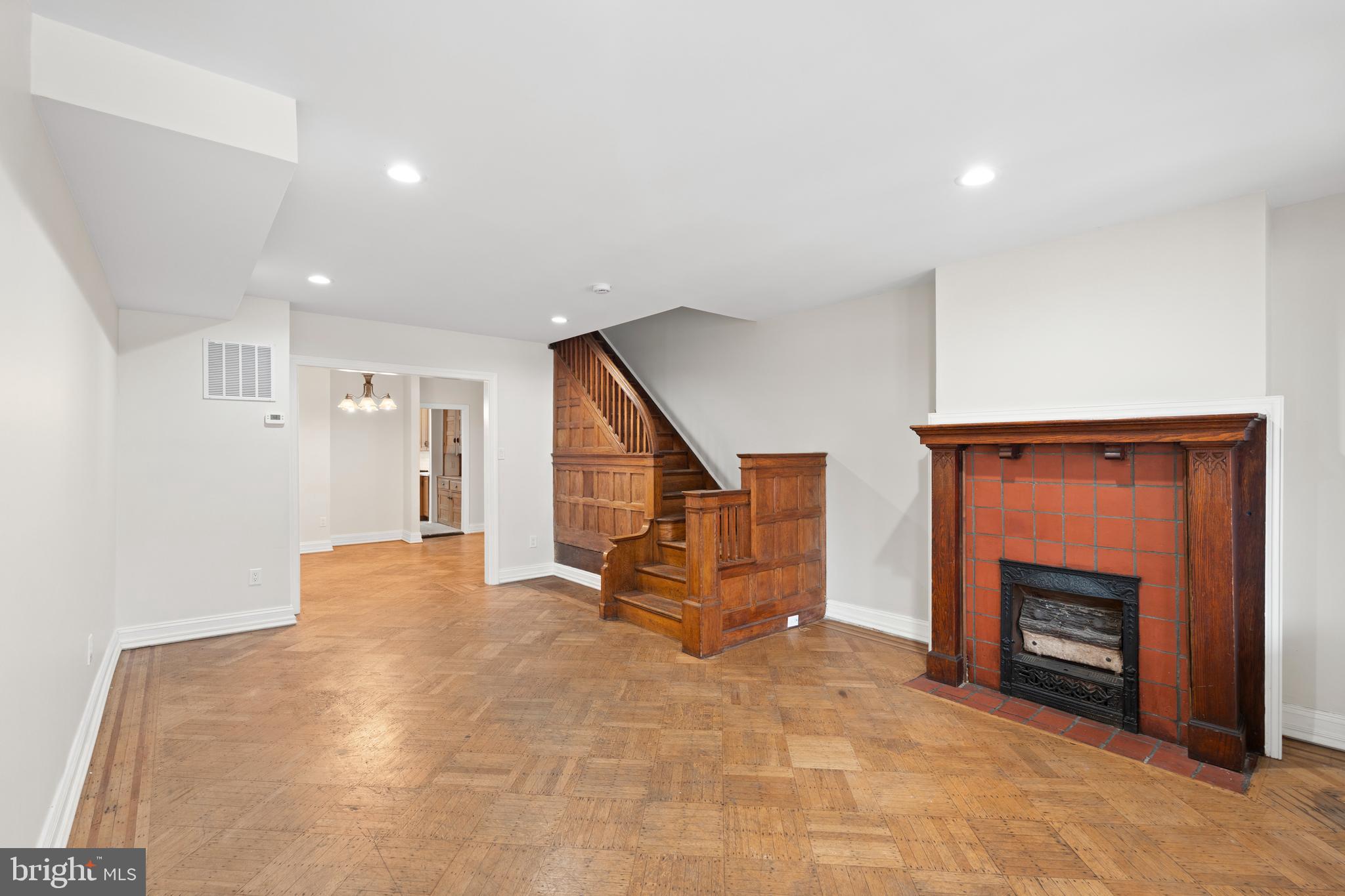 619 South 42nd Street Philadelphia, PA 19104 - Photo 5 of 30 a view of an empty room with wooden floor and a fireplace