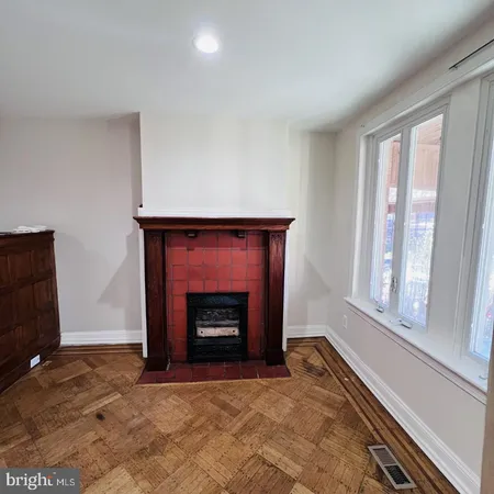 a view of an empty room with a fireplace and a window