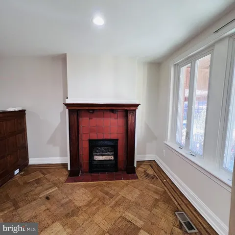 a view of an empty room with a fireplace and a window