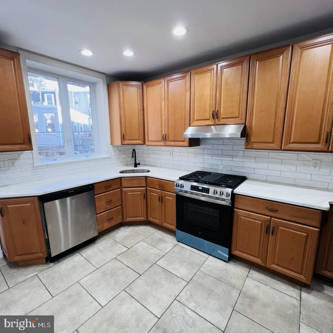 619 South 42nd Street Philadelphia, PA 19104 - Photo 8 of 25 a kitchen with stainless steel appliances granite countertop a stove a sink and a microwave
