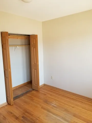 an empty room with wooden floor and closet